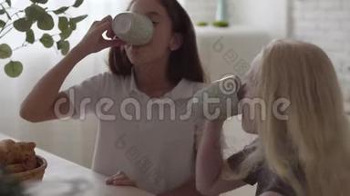 可爱的小白化病女孩喝茶，看着对方在家笑。 友谊的概念。 免费